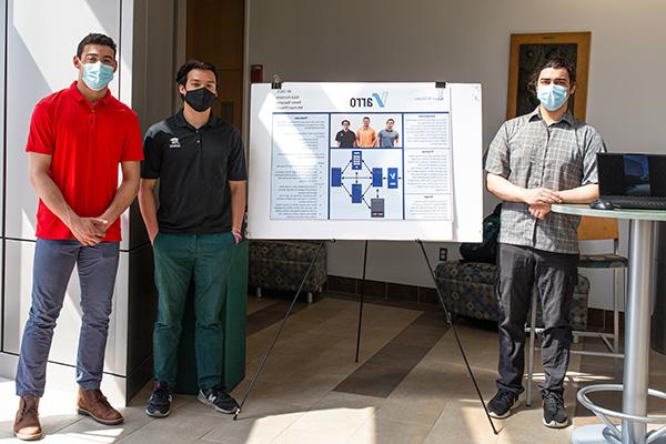 Three Computer Science students stand next to their poster at SASH 